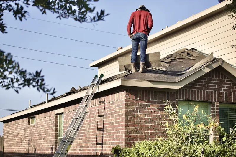 Professional roofer working on a residential roof in Postwoods